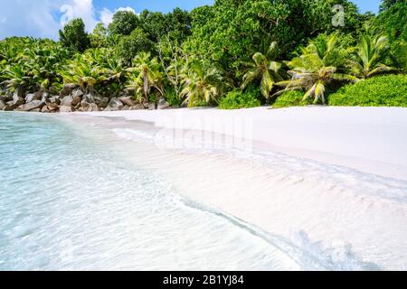 Gentle waves at Anse Cocos tropical beach on la digue island, Seychelles. Exotic holiday vacation concept Stock Photo