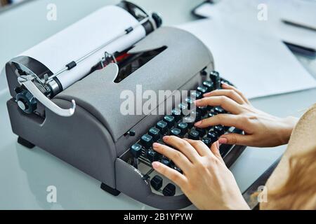 close up of woman typing with old typewriter Stock Photo