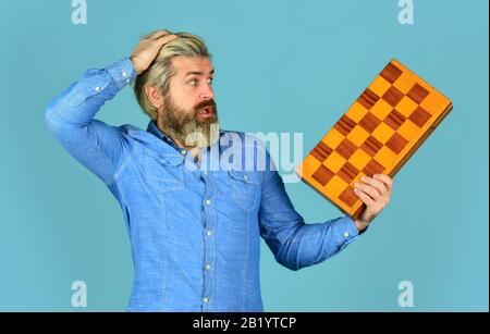 oh my god. intelligence quotient concept. human brain working. brainstorming concept. play chess tournament. Intelligence level measurement. level up your iq. surprised bearded man hold chess board. Stock Photo