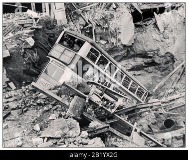 THE LONDON BLITZ BUS BOMB CRATER WW2 1940’s Nazi Air Raid Bomb Damage in Britain during the Second World War In the aftermath of a bombing raid, a London bus lies in a bomb crater in Balham, South London. World War II Stock Photo