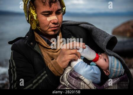 Lesbos, Greece. 28th Feb, 2020. A refugee from Afghanistan feeds his baby after they arrive on the Greek island of Lesbos. According to the state news agency Anadolu, a spokesman for the Turkish ruling party AKP has hardly concealed his threat to open the borders for refugees in the country. Credit: Angelos Tzortzinis/dpa/Alamy Live News Stock Photo