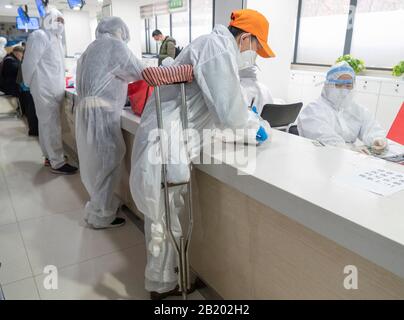 Wuhan, Hubei Province, China. 28th Feb 2020. (200228) -- WUHAN, Feb. 28, 2020 (Xinhua) -- Physically disabled Yu Guoqiao (front) handles medicine-taking procedures for a community's disabled patients at a drug store in Wuhan, central China's Hubei Province, Feb. 27, 2020. Yu Guoqiao is a facilitator of a disabled people group at a community in Hanyang District of the coronavirus-hit Wuhan. Since the outbreak of the virus, Yu has overcome difficulties to insistently take medicines for the community's nearly 300 disabled patients. Credit: Xinhua/Alamy Live News Stock Photo