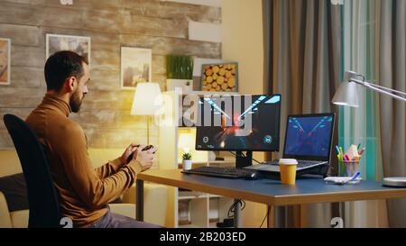 Bearded engineer playing video games with joystick and lost it. Game over. Stock Photo