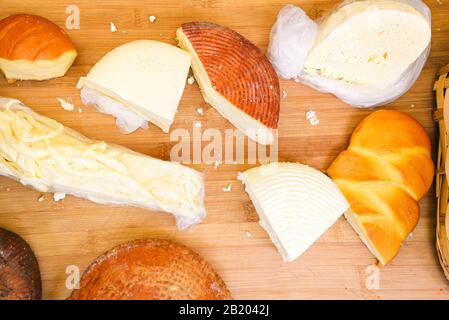 Different varieties of cheese on a wooden board. Hard and soft fresh slices of cheese Stock Photo