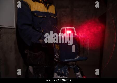 professional worker using laser level in a building under construction. Laser equipment at a construction site Stock Photo