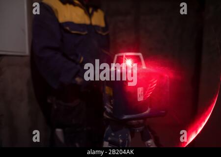 professional worker using laser level in a building under construction. Laser equipment at a construction site Stock Photo