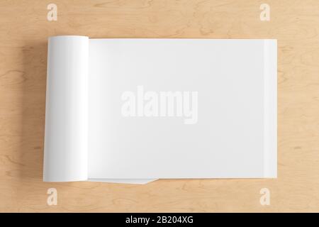 Blank horizontal right magazine page. Workspace with folded magazine mock up on wooden desk. View above Stock Photo