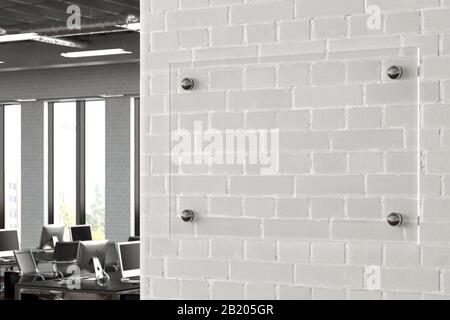 Blank horizontal transparent glass sign plate on the white brick wall in office. Name plate mock up. Side view Stock Photo