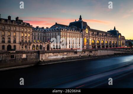 Musee d'Orsay during a beautiful summer sunset with boat trails cruising on Seine River. Paris, France. Stock Photo