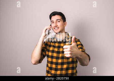 satisfied client. man speaking on the phone showing big thumb up Stock Photo