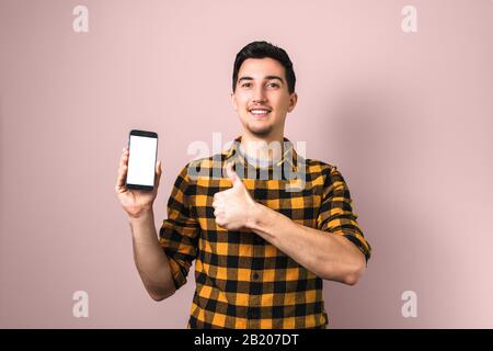satisfied client. man holding a phone with white screen showing big thumb up Stock Photo