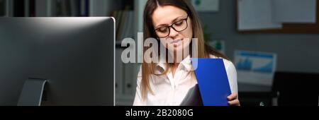 Woman opened folder with documents examines them Stock Photo