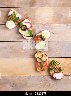 Healthy sandwiches with radish avocado, tomatoes, radish and quail eggs. Stock Photo