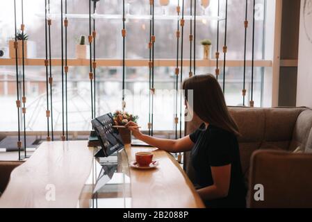 Portrait of young woman in casual clothes who writing on digital tablet. Stock Photo