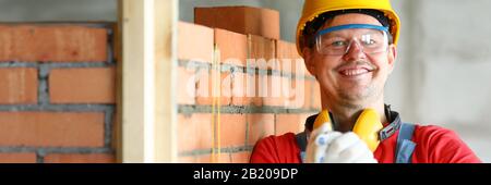 Worker at construction site making friendship gesture in protective gloves Stock Photo