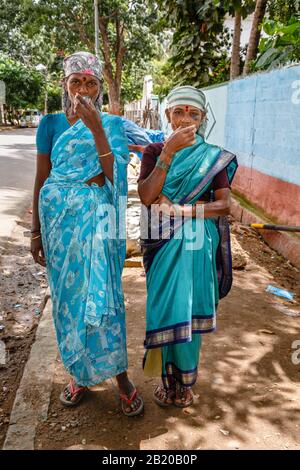 BENGALURU, INDIA - October 24, 2012. Two indian women dressed in saris drink tea whilst on a break from manual work in Bangalore, India Stock Photo