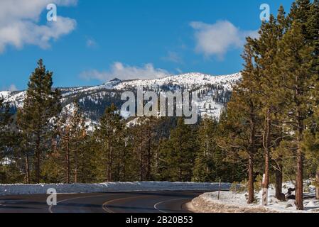 Landscape of trees and snow dappled mountains along curve in Mount Rose Scenic Byway, Incline Village Nevada Stock Photo