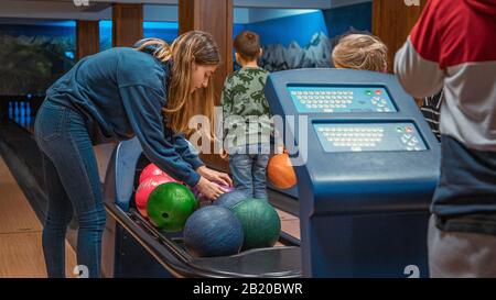 Young girl picking bowling ball Stock Photo