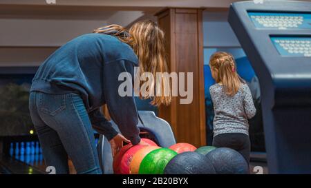 Young girl picking bowling ball Stock Photo