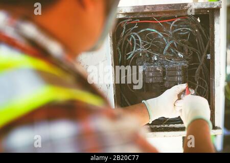 technician checking electrical switch board on fire short circuit Stock Photo