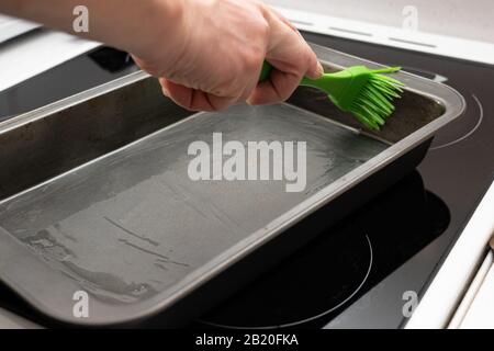 greasing baking sheet with oil. Cooking a cake tin Stock Photo