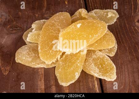 Lot of slices of dried yellow pineapple on brown wood Stock Photo