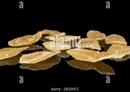 Lot of slices of light dried yellow pineapple isolated on black glass Stock Photo