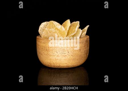 Lot of slices of dried yellow pineapple in bamboo bowl isolated on black glass Stock Photo