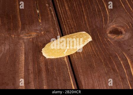 One slice of dried yellow pineapple on brown wood Stock Photo