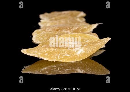 Lot of slices of sweet dried yellow pineapple isolated on black glass Stock Photo