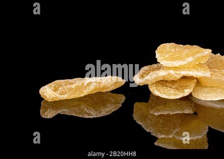 Lot of slices of dried yellow pineapple isolated on black glass Stock Photo