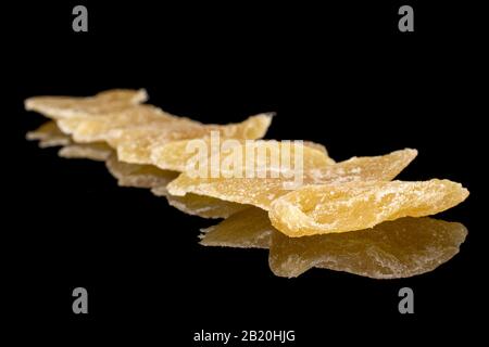 Lot of slices of dried yellow pineapple isolated on black glass Stock Photo