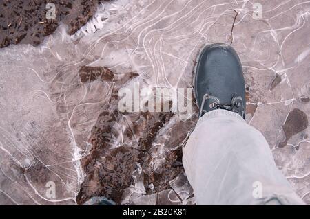 Black work boots on ice covered ground. Work shoes for work. Stock Photo