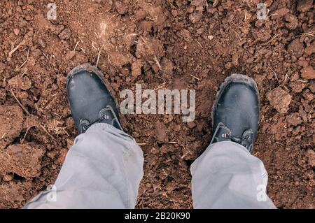Work boot isolated on clay soil. Shoes for work. Stock Photo