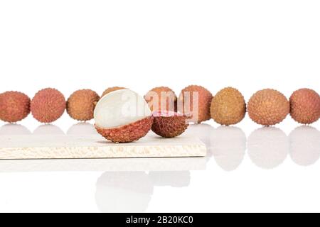Lot of whole one piece of fresh lychee on wooden cutting board isolated on white background Stock Photo