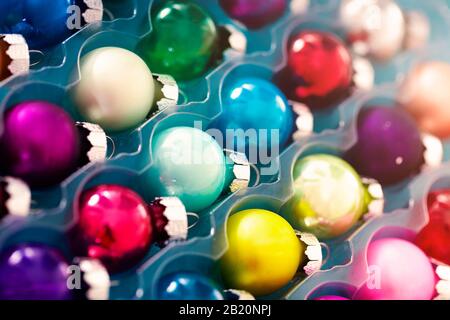 Closeup set of colorful rounded decorated Christmas balls in plastic transparent container Stock Photo