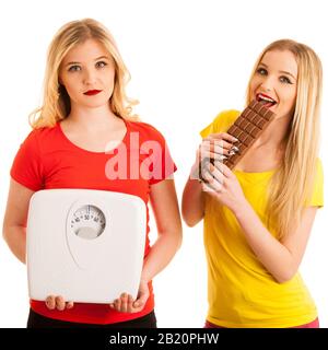 happy woman eating chocolate and having fun about worried woman with scale isolated over white Stock Photo