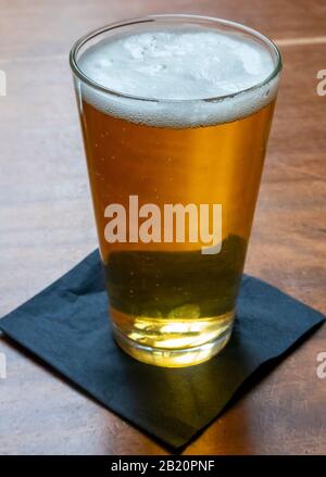 A tall glass of draught lager beer in a plain tall glass Stock Photo