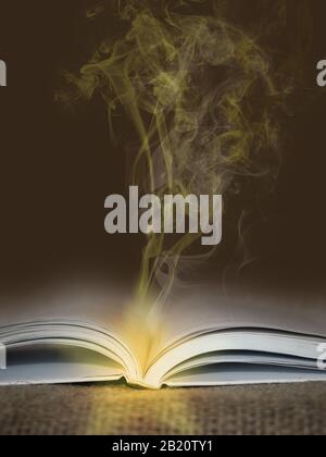 Open book with glowing yellow smoke going from it - magic and mystic concept Stock Photo