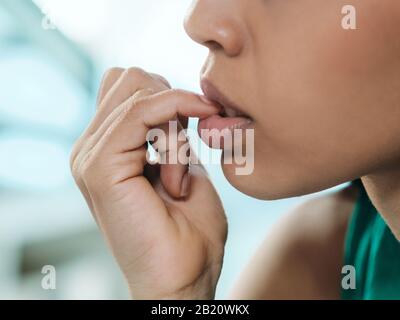 Young Black Woman Feeling Anxious And Biting Nails Stock Photo