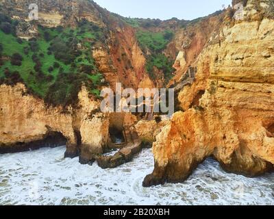 Aerial photo above view of Ponta da Piedade headland with group of rock formations yellow-golden cliffs along limestone coastline, Lagos town Portugal Stock Photo