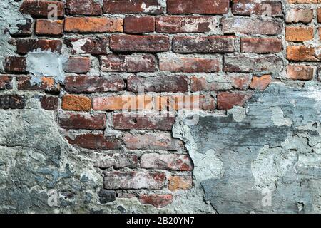 Dilapidated red brick wall, old ruined facade. Urban grunge stonewall, destroyed building, cement architecture background Stock Photo