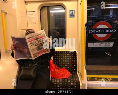 London, UK. 28th Feb 2020.Person on London Underground reading latest news headlines of  Coronavirus Credit: credit: Matt Pennington / Alamy Live News Stock Photo