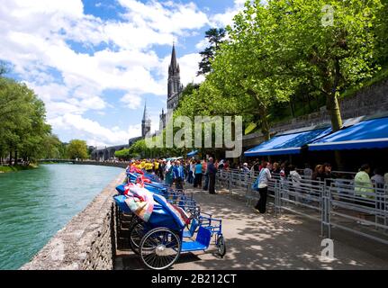 Pilgrims in front of the Baths, Basilica of the Rosary and Basilica of the Immaculate Conception, Lourdes, Hautes Pyrenees, France Stock Photo