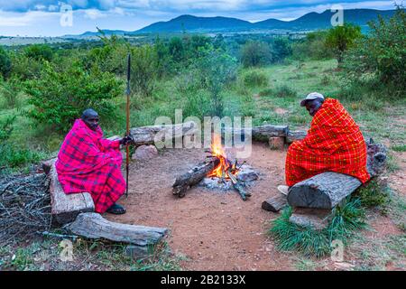 Maasai men around a campfire, Masai Mara National Park, Kenya Stock Photo