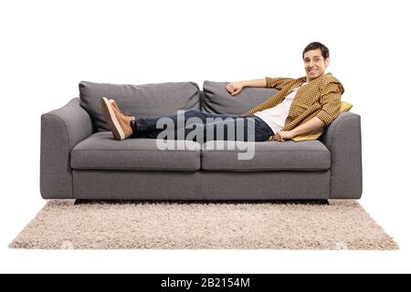 Young man sitting comfortably on a sofa isolated on white background Stock Photo