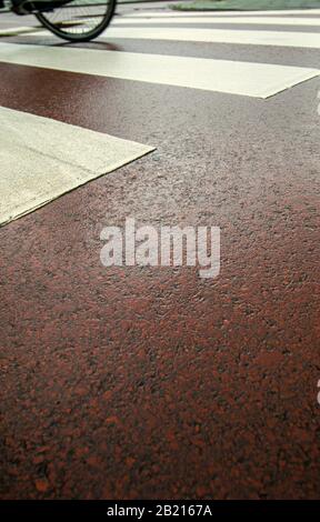 Cyclist riding over a road crossing for pedestrians Stock Photo