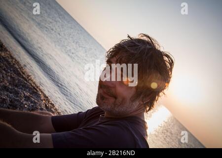 Portrait of handsome middle aged man looking at camera / Sunset. Close-up Stock Photo