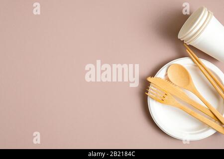 Eco-friendly bamboo cutlery, paper cups and plate. Flat lay, top view. Sustainable lifestyle. Zero waste, plastic free concept Stock Photo