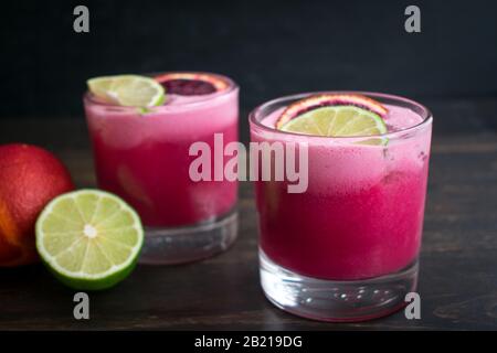 Coconut Blood Orange Margaritas: A pair of tequila cocktails made with blood orange, lime, and coconut Stock Photo